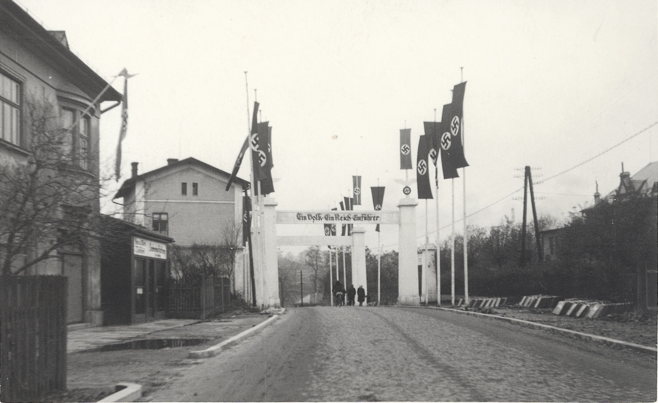 Vlevo část domu čp. 128 (Stolařství Leo Stenchly) na Komenského ulici. Naproti budova Turnhalle. Výzdoba z období nacistické okupace (1939).