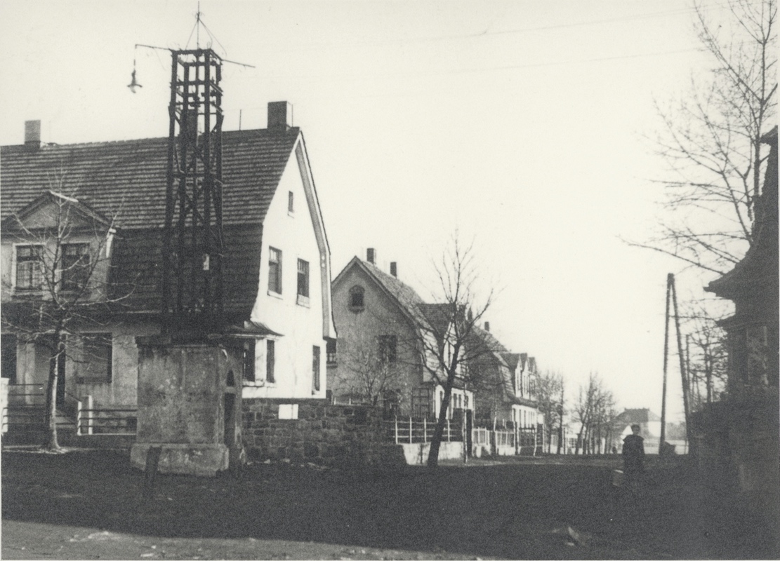 Pohled z křižovatky na ulici Průmyslové v Lesní kolonii (Nový Jork): zleva dům čp. 1318, za ním čp. 1319 a čp. 1320. Vpravo roh domu čp. 1312. V dálce dům čp. 1604 na ulici Úřednické. Varianta s vyznačenými čísly popisnými na následujícím snímku... (Identifikace fotografie: Petr Bindač)
