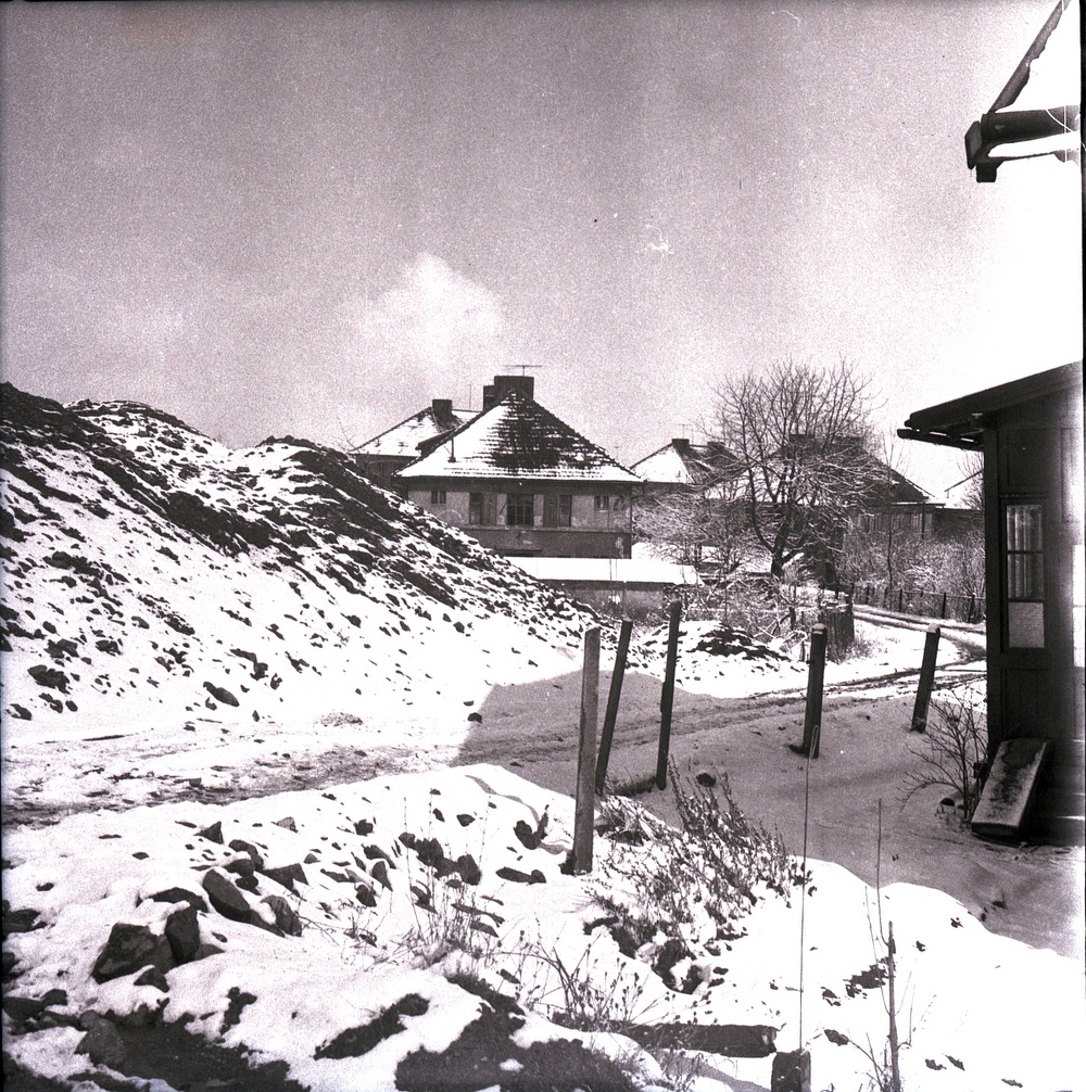 Pohled z Doubravské (Bezručovy) ulice. V popředí dům čp. 1349 (Potraviny družstva Budoucnost), za ním dům čp. 1353. Naproti nim domy čp. 1350, 1351 a 1354. Úplně vpravo část Obecního učitelského domu čp. 1187. Varianta s vyznačenými čísly popisnými na následujícím snímku... (Lokalizace objektů: Petr Bindač)