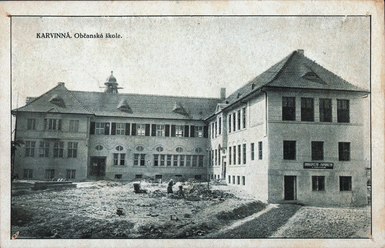 Masarykova měšťanská škola byla postavena v letech 1921–1922. (Černobílá pohlednice, vyšla nákladem Jindřišky Krůtové, knihkupectví, Karviná, kolem roku 1922, Státní okresní archiv Karviná, 726)