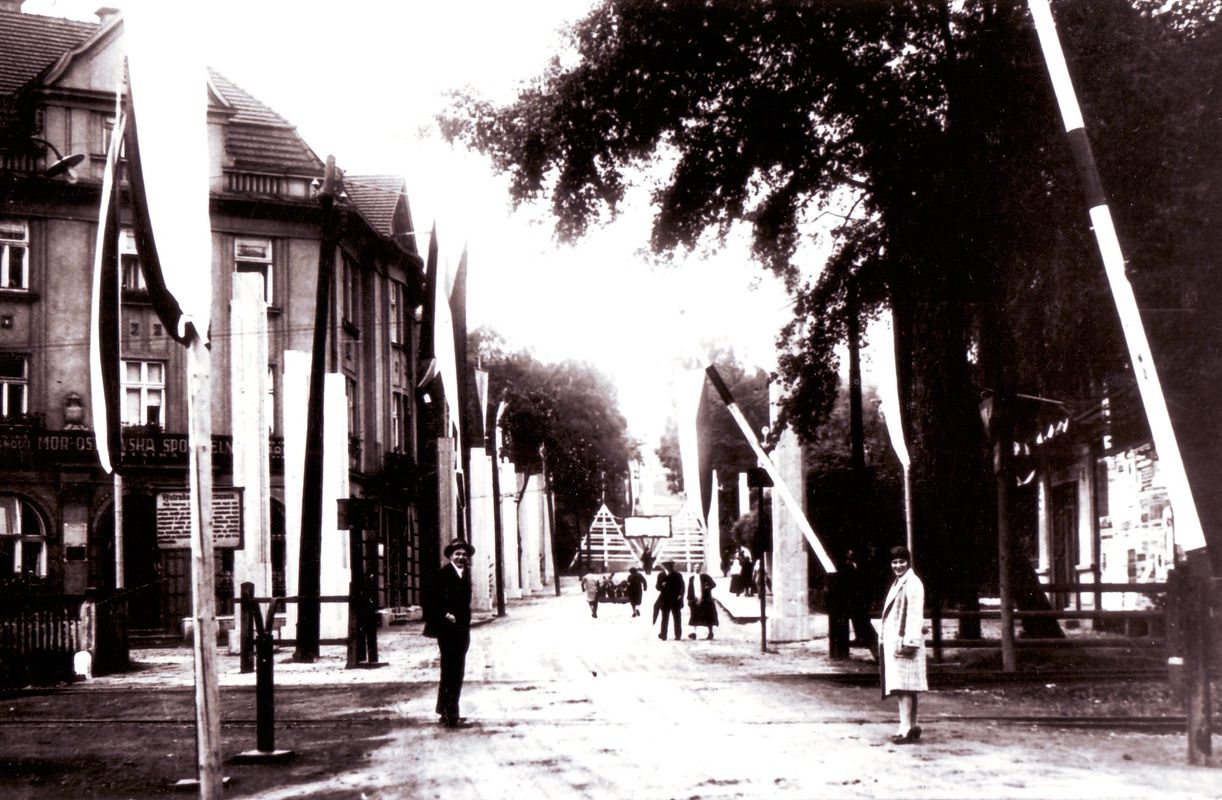 Železniční přejezd a v levé části budova Městské spořitelny