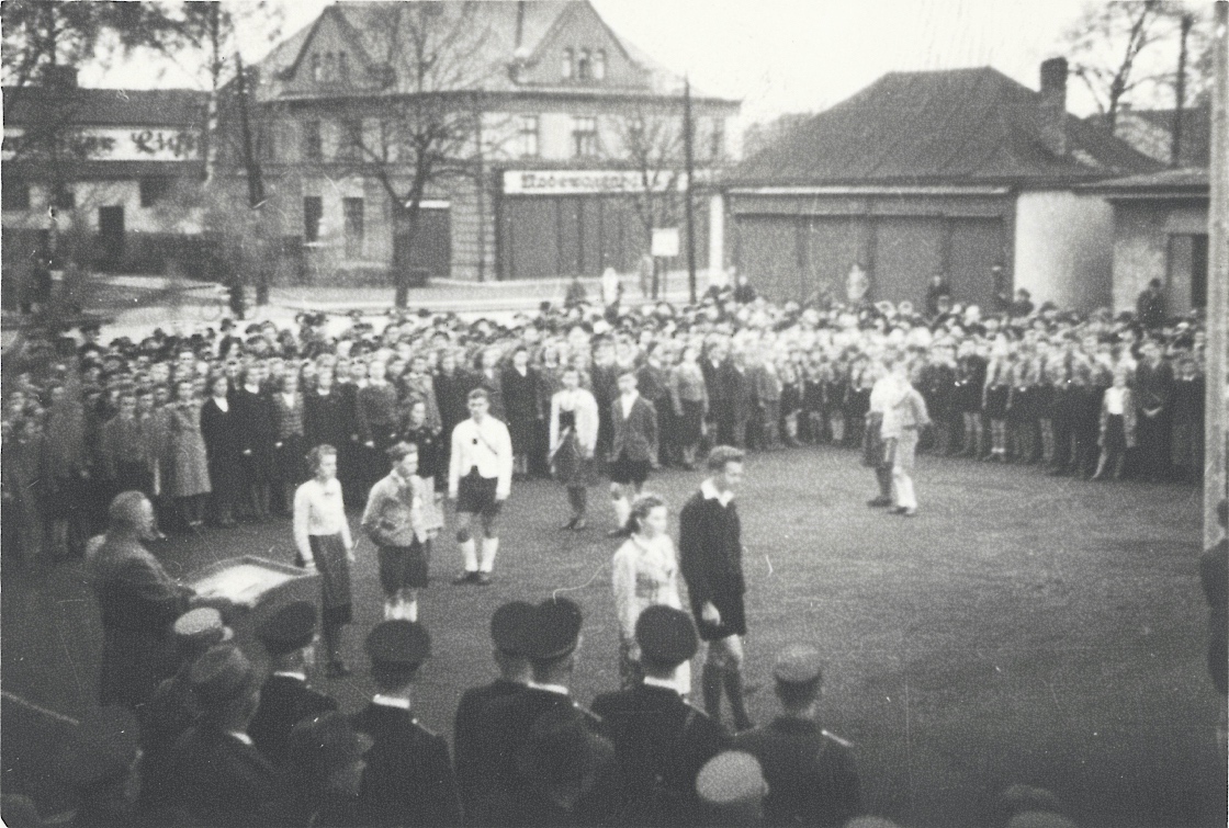 Záběry z oslav Májových ohňů v roce 1940 v Karvinné. Fotografováno na tržišti u Závodního hotelu: vlevo budova kina Central (čp. 1606), dům uprostřed čp. 1552 (textil Merta), malá budova vpravo je čp. 1348, úplně napravo pak roh hasičské zbrojnice (čp. 1639).