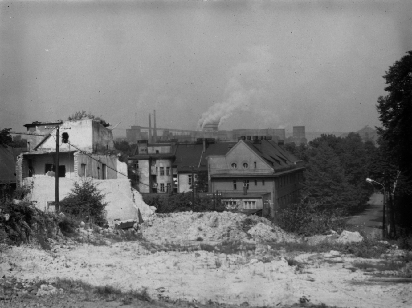 Pohled ze Soleckého kopce na probíhající demolici domu čp. 1613. V pozadí dům čp. 1560 a Důl ČSA. Konec 50. let 20. století. (Zdroj: E. Schweserová, P. Bindač: SOLCA Tajemství zámeckého parku = KLIK NA FOTOGRAFII. Foto: Ing. Jan Válek)