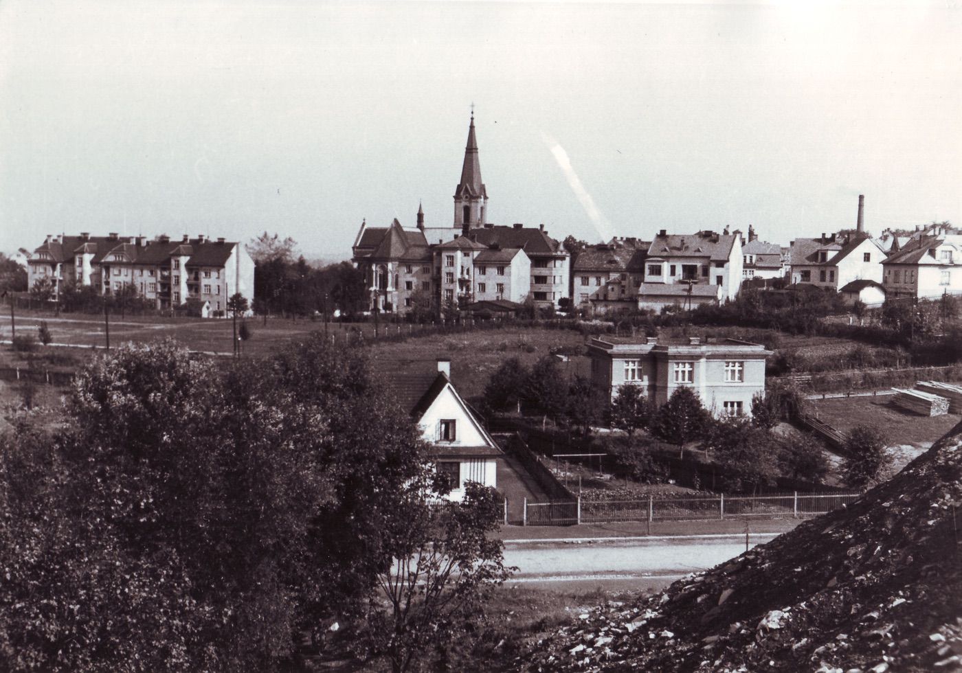 Pohled na kostel sv. Jindřicha a centrum staré Karvinné přes část Lelkovy ulice. Vpravo v popředí vila čp. 1570 (stavitel Daniel), vlevo (zpola zakrytý za stromy) dům čp. 1457 z Lelkovy kolonie.