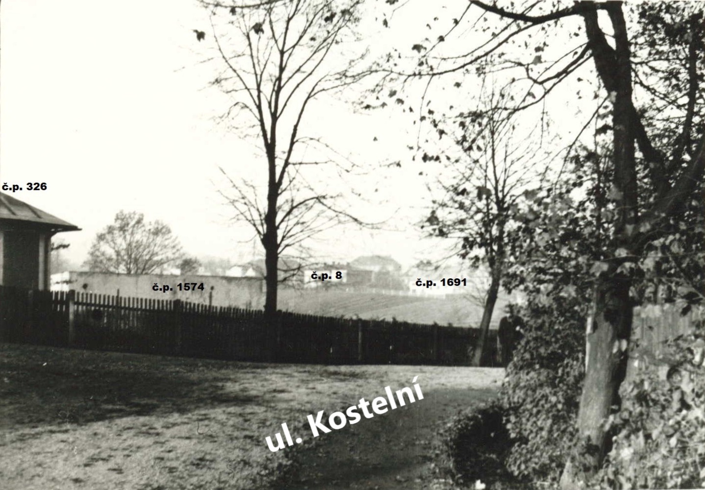 Pravděpodobně se jedná o záběr z křižovatky ulic Radniční a Kostelní z doby před rokem 1929. Vlevo roh domu čp. 326, za plotem snad objekt čp. 1574 před adaptací na Židovskou modlitebnu. Uprostřed v dálce dům čp. 8 (Drogerie Matiasowitz) a vpravo dům čp. 1691 (Drogerie a Dr. Pazdziora). (Identifikace a označení objektů: Petr Bindač)