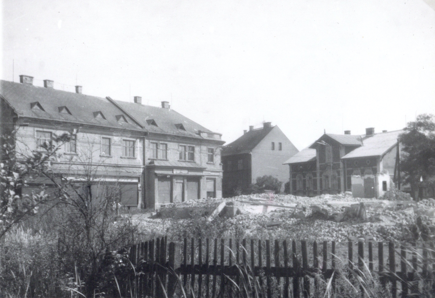 Vlevo nový obchodní dům Rudolf Žižka (čp. 1610), uprostřed dům čp. 1698 (Sedlářství František Fill), vpravo pak budova čp. 986. Hromada suti uprostřed - pozůstatky Řeznictví Molenda (čp. 1244).