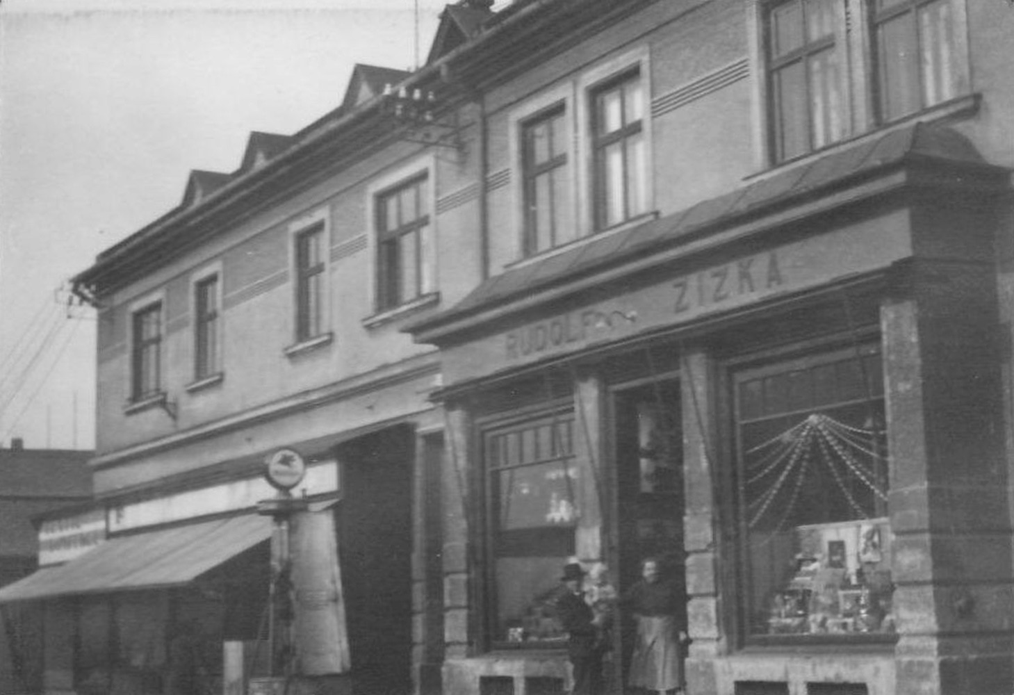 Obchodní dům Rudolf Žižka (čp. 1610) na snímku z období 2. světové války. Vlevo benzínová pumpa. (S laskavým svolením vnuka p. Žižky, z rodinného alba)