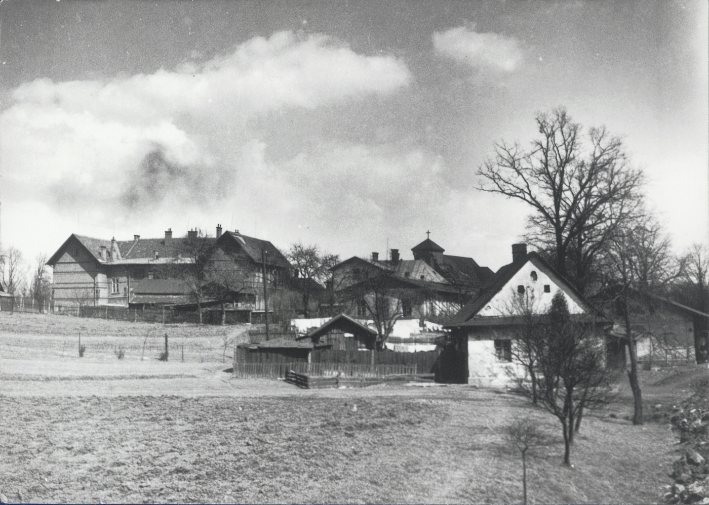 V popředí dům čp. 443, za ním část domu čp. 19. V pozadí budova tzv. Červené školy a kostel sv. Petra z Alkantary.