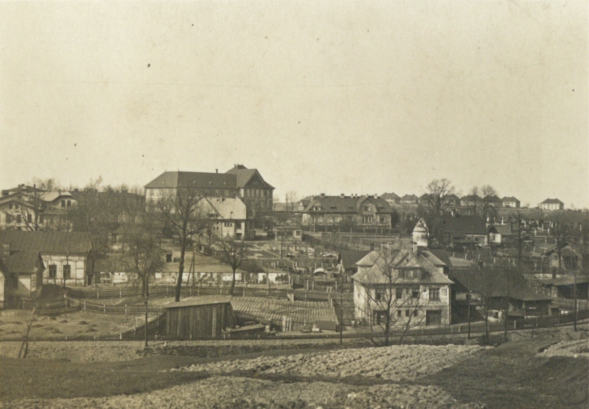 Světlá vila v popředí snímku: dům čp. 1564 (stolařství Salik, Hudební nástroje Hubený). Vpravo přiléhá těsně k vile dům čp. 91, za ním světlý dům čp. 23. Velká budova uprostřed snímku: Městský chudobinec, čp. 1581, přímo před ním stojí Restaurace Josef Baier (čp. 1444). Vpravo pak budova čp. 1270 a na horizontu jsou patrné domy kolonie Jindřichův dvůr. Vlevo v popředí část domu čp. 26 (Antonín Gritner).