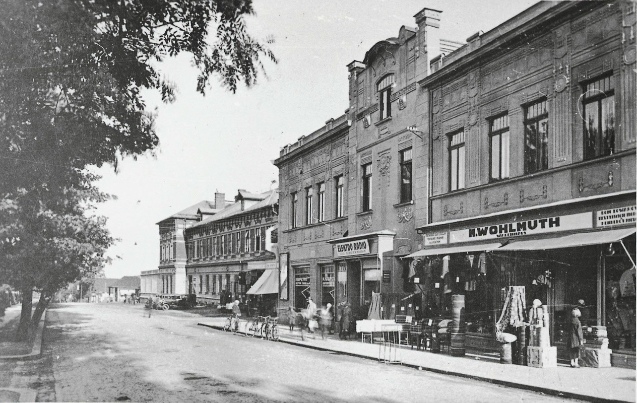 Hlavní třída v Karvinné s obchody Módním, textilním, rukodělným a konfekčním zbožím Moritz Wohlmuth, Elektro-rádio a se Závodním hotelem. (Fotografie kolem roku 1930, soukromá sbírka)