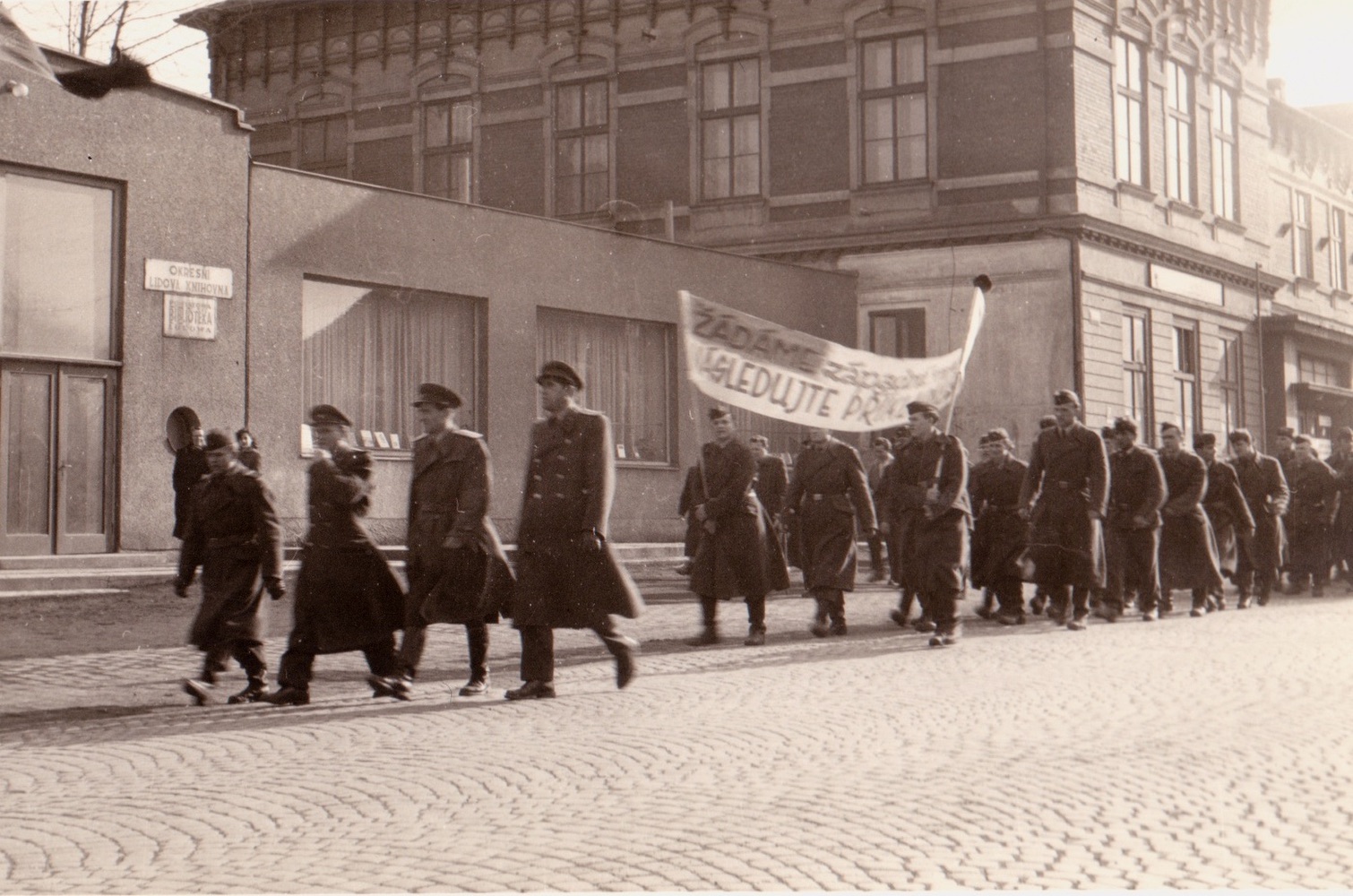 Záběr z manifestace proti zbrojení a nukleárním zbraním v Karviné 14.4.1958. V pozadí budova Závodního hotelu (čp. 4) a vlevo částečně i Kulturního domu (čp. 1075)