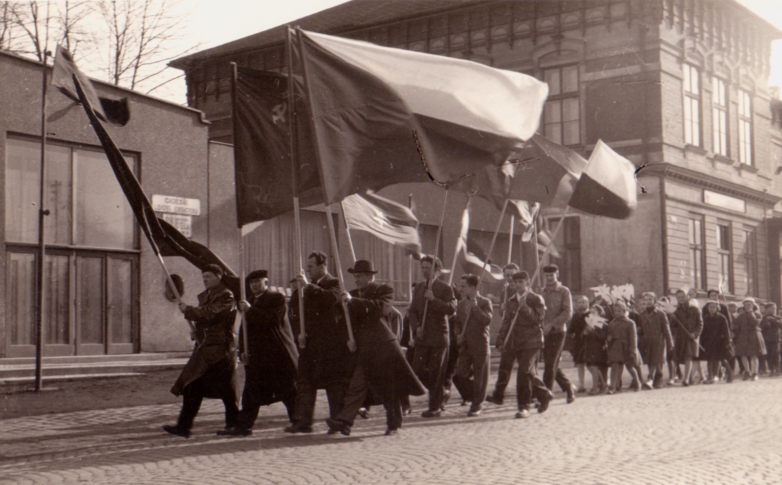 Záběr z manifestace proti zbrojení a nukleárním zbraním v Karviné 14.4.1958. V pozadí budova Závodního hotelu (čp. 4) a vlevo částečně i Kulturního domu (čp. 1075)