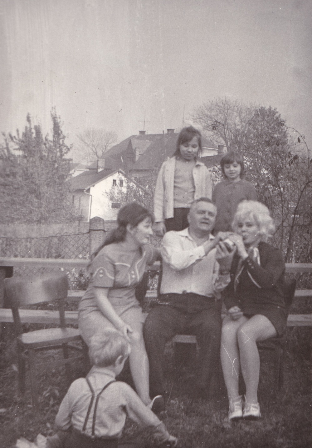 Momentka ze života...(Rodinná oslava v roce 1973 na zahradě Restaurace Ručka, čp. 459) V pozadí velký dům čp. 404 (Potraviny Bielesz), před ním takřka skrytý za stromem dům čp. 869 (Řeznictví Folwarczny), vzadu pak část střechy domu čp. 1571 (S laskavým svolením p. Eriky Schweserové, ze soukromé sbírky)