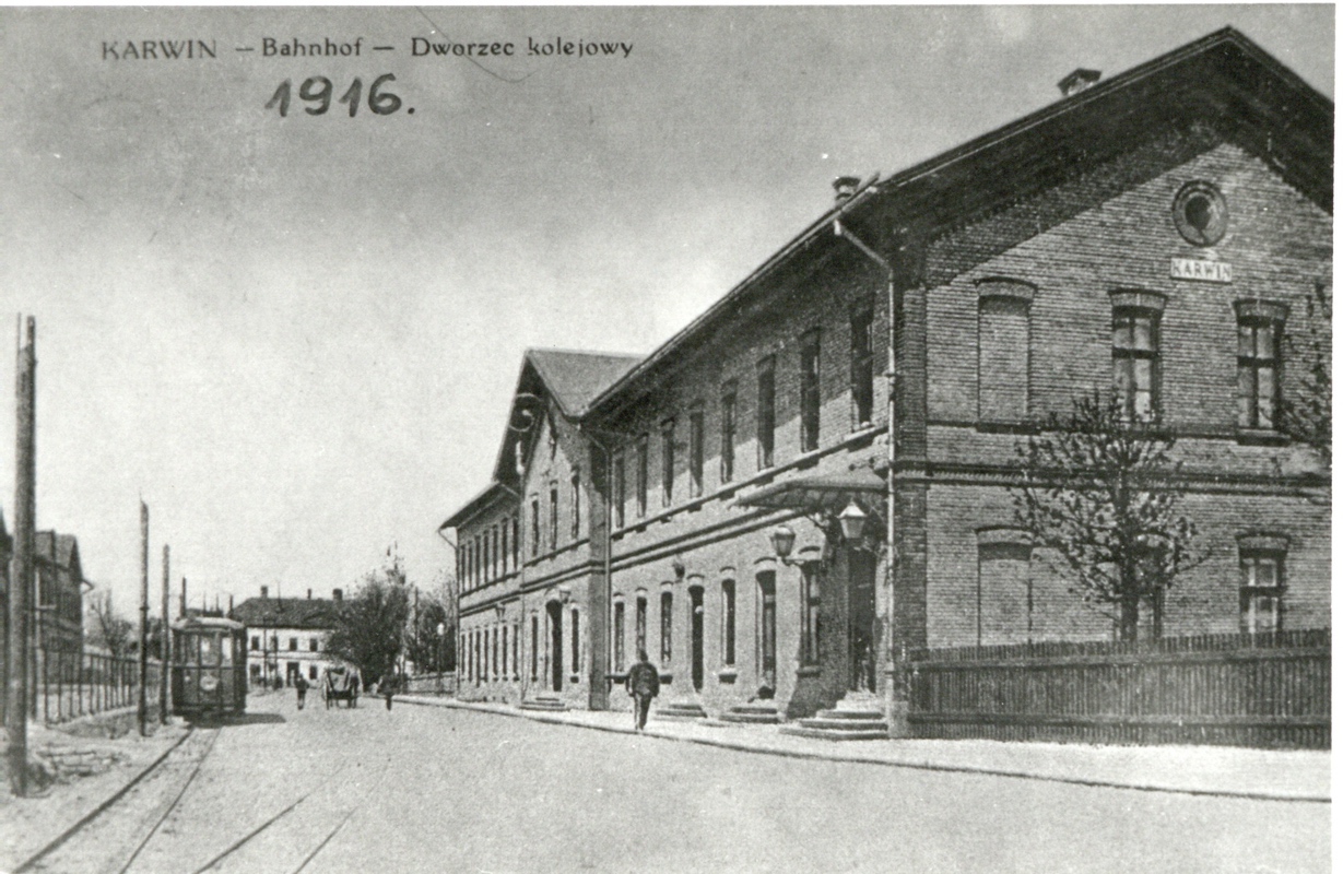 Hlavní nádraží Košicko-bohumínské dráhy v Karvinné bylo zřízeno v roce 1868. Naproti nádražní a zahradní Restaurace Kubásek byla konečná zastávka č. 18 místní Ostravsko-karvinské úzkorozchodné dráhy. Bílá budova v pozadí je Restaurace Garni Haubenstock.