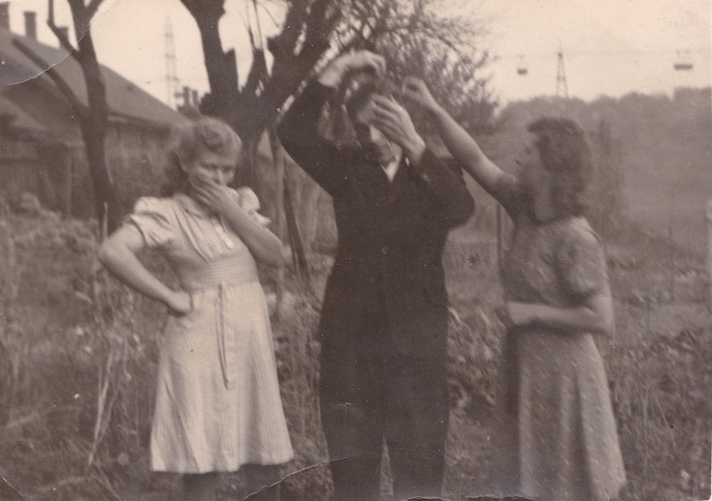 Momentka ze života aneb příprava na fotografování... Snímek pořízený na zahradě domu čp. 664, vlevo dům čp. 601 a v pozadí snímku je patrná uhelná lanovka z dolu Gabriela na ÚZK s vozíky (S laskavým svolením p. Eriky Schweserové, ze soukromé sbírky)