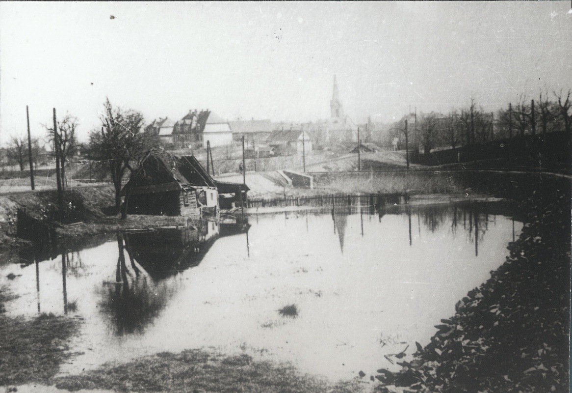 V popředí u trati (na kraji zatopené oblasti) pozůstatky domu čp. 76. V pozadí centrum města a kostel sv. Jindřicha. (Lokalizace snímku: Jan Polakovič)