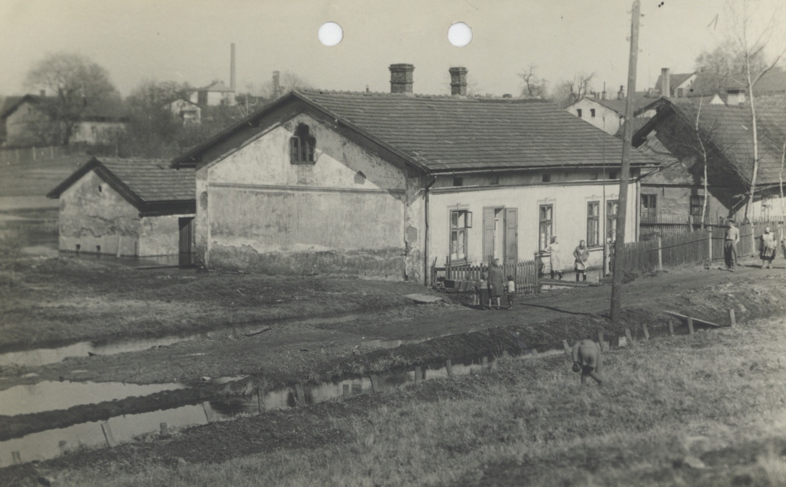 V popředí dům čp. 954, vpravo za ním dům čp. 523. Vlevo vzadu (za velkým stromem) dům čp. 1221, napravo od něj pak štít domu čp. 1206; patrový dům před komínem čp. 1597, 1598 a v pozadí těžní věž dolu Františka. Na pravé straně snímku (dům o půdorysu písmene L, s vysokým komínem) je vidět Pekařství Zawila čp. 954, za ním pak ještě vysoký štít domu čp. 656. (Identifikace objektů: Jan Polakovič)
