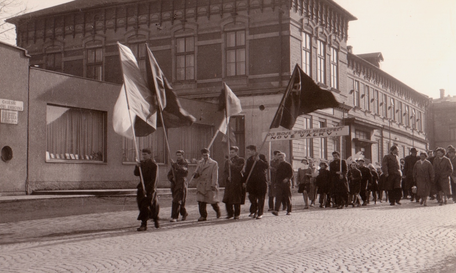 Záběr z manifestace proti zbrojení a nukleárním zbraním v Karviné 14.4.1958. V pozadí budova Závodního hotelu (čp. 4) a vlevo částečně i Kulturního domu (čp. 1075)