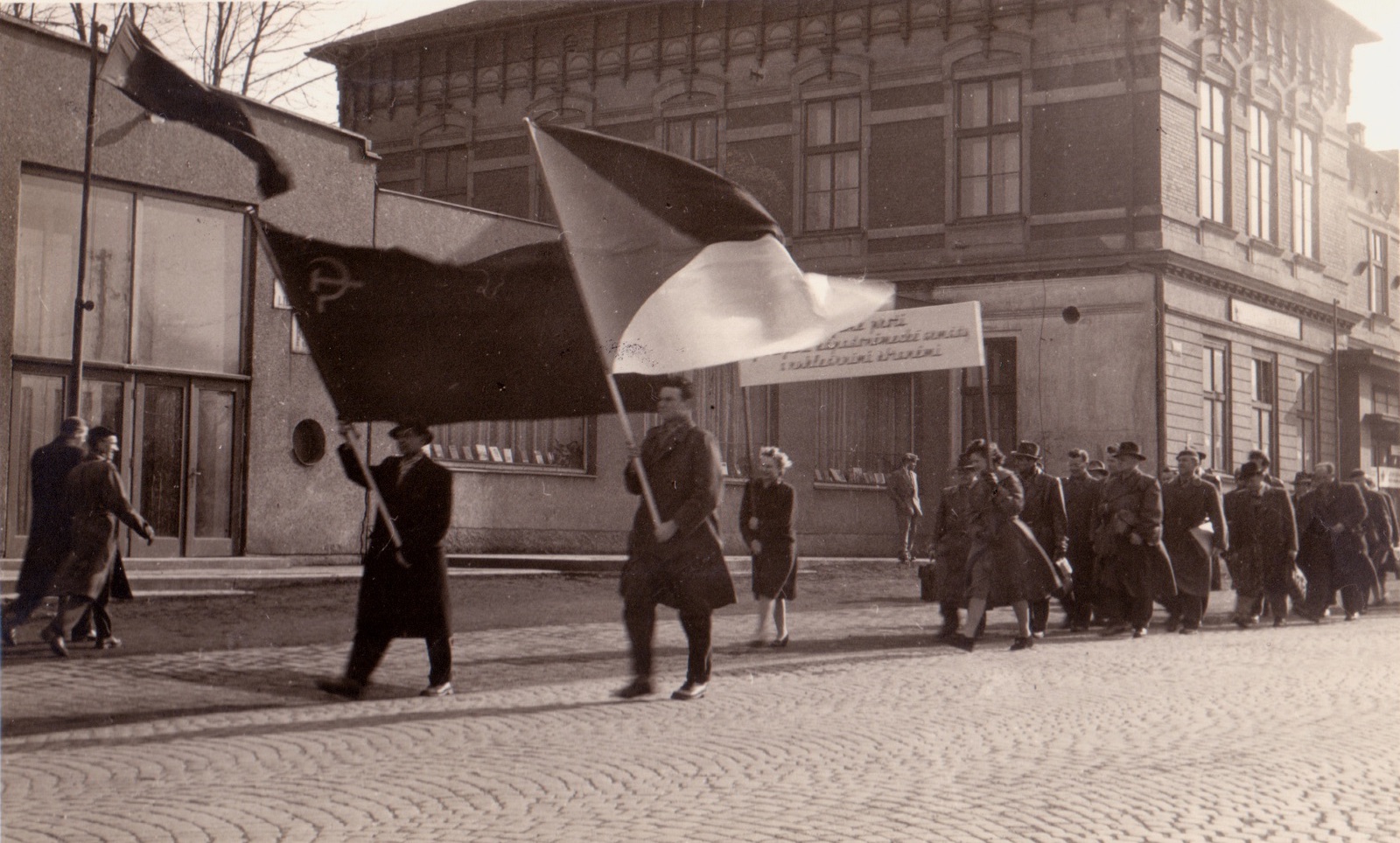 Záběr z manifestace proti zbrojení a nukleárním zbraním v Karviné 14.4.1958. V pozadí budova Závodního hotelu (čp. 4) a vlevo částečně i Kulturního domu (čp. 1075)