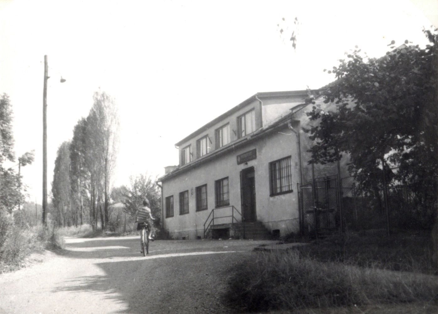 Dům čp. 494 v Karviné-Dolech na snímku z roku 1974. V období od roku 1966-1978 zde byla prodejna potravin. Fotografie zachycuje pohled směrem od kapličky nahoru k finským domkům. (Identifikace snímku: Petr Bindač)
