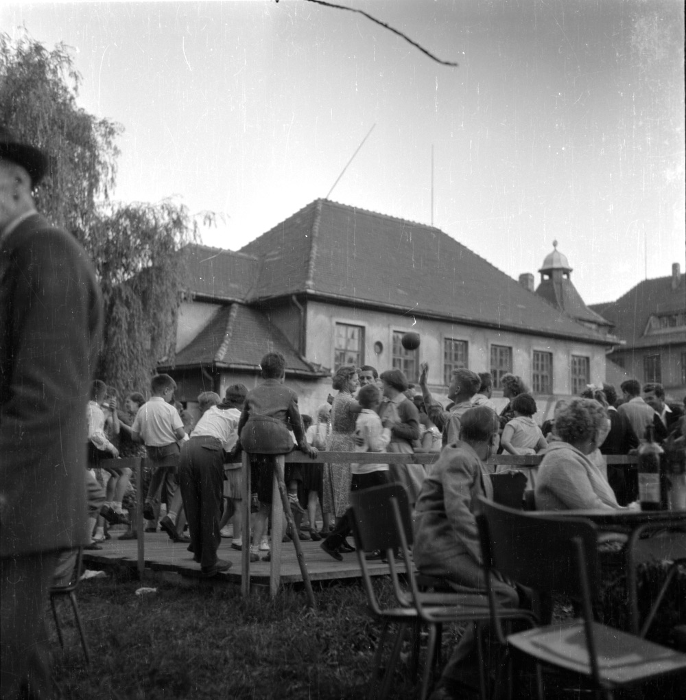Záběr z dětských radovánek konaných v prostorách za Masarykovou měšťanskou školou pravděpodobně v roce 1958. V pozadí budova tělocvičny. (S laskavým svolením p. Radomíra Burdy, z rodinné sbírky)