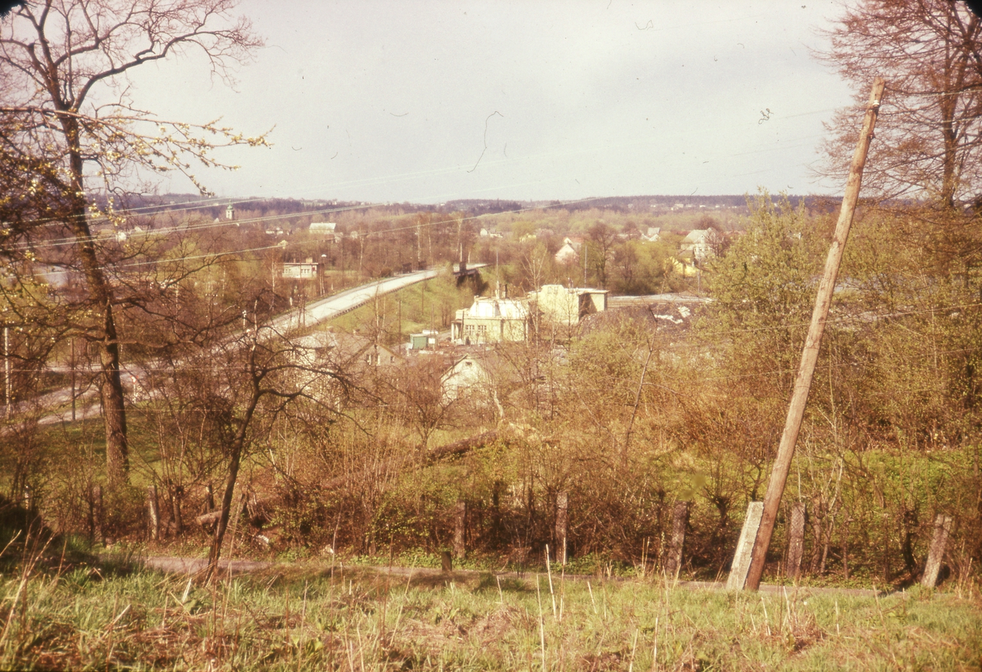 V popředí, ukrytý za stromy, dům čp. 28 (poslední obyvatelé: Bystroňovi), vpravo za ním dům čp. 337 (Pošta) a čp. 261 (Obchod smíšeným zbožím) ve stavu demolice. Vlevo za mostem Železniční zastávka Louky čp. 107 (se svolením autora fotografie p. Bronislava Filipczyka, ze soukromé sbírky)