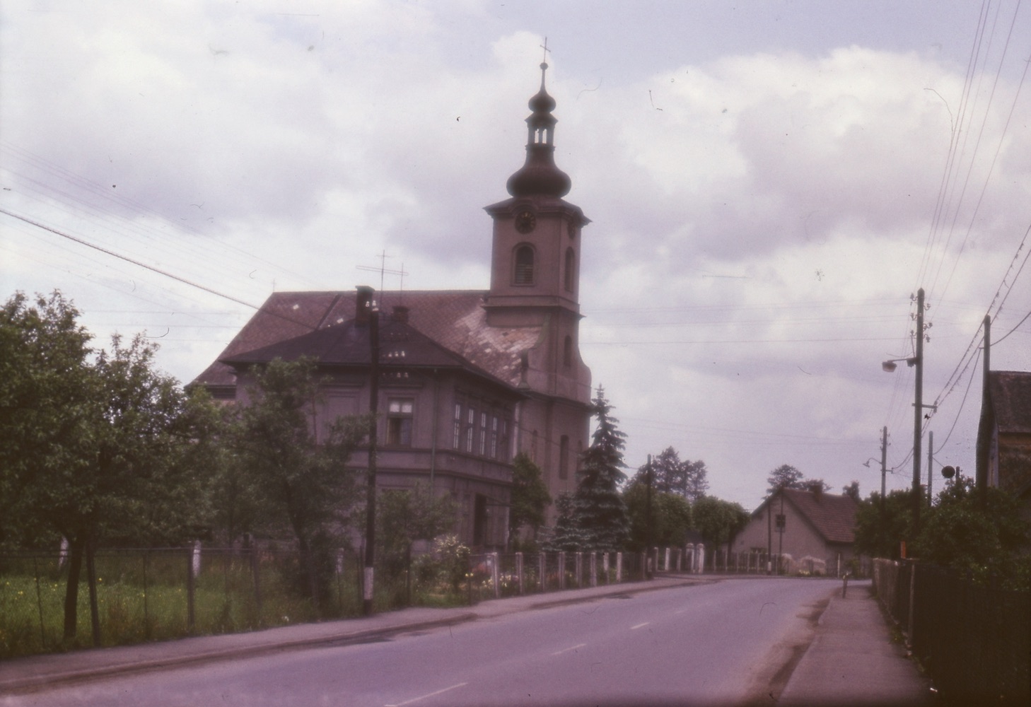Vlevo budova Farního úřadu v Loukách čp. 29, za ní kostel sv. Barbory (se svolením autora fotografie p. Bronislava Filipczyka, ze soukromé sbírky)