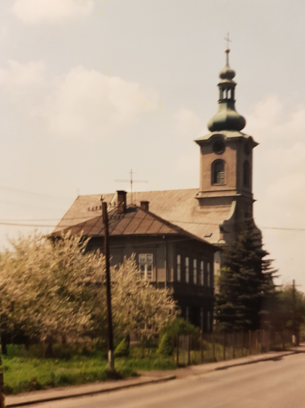 Vlevo budova Farního úřadu v Loukách čp. 29, za ní kostel sv. Barbory