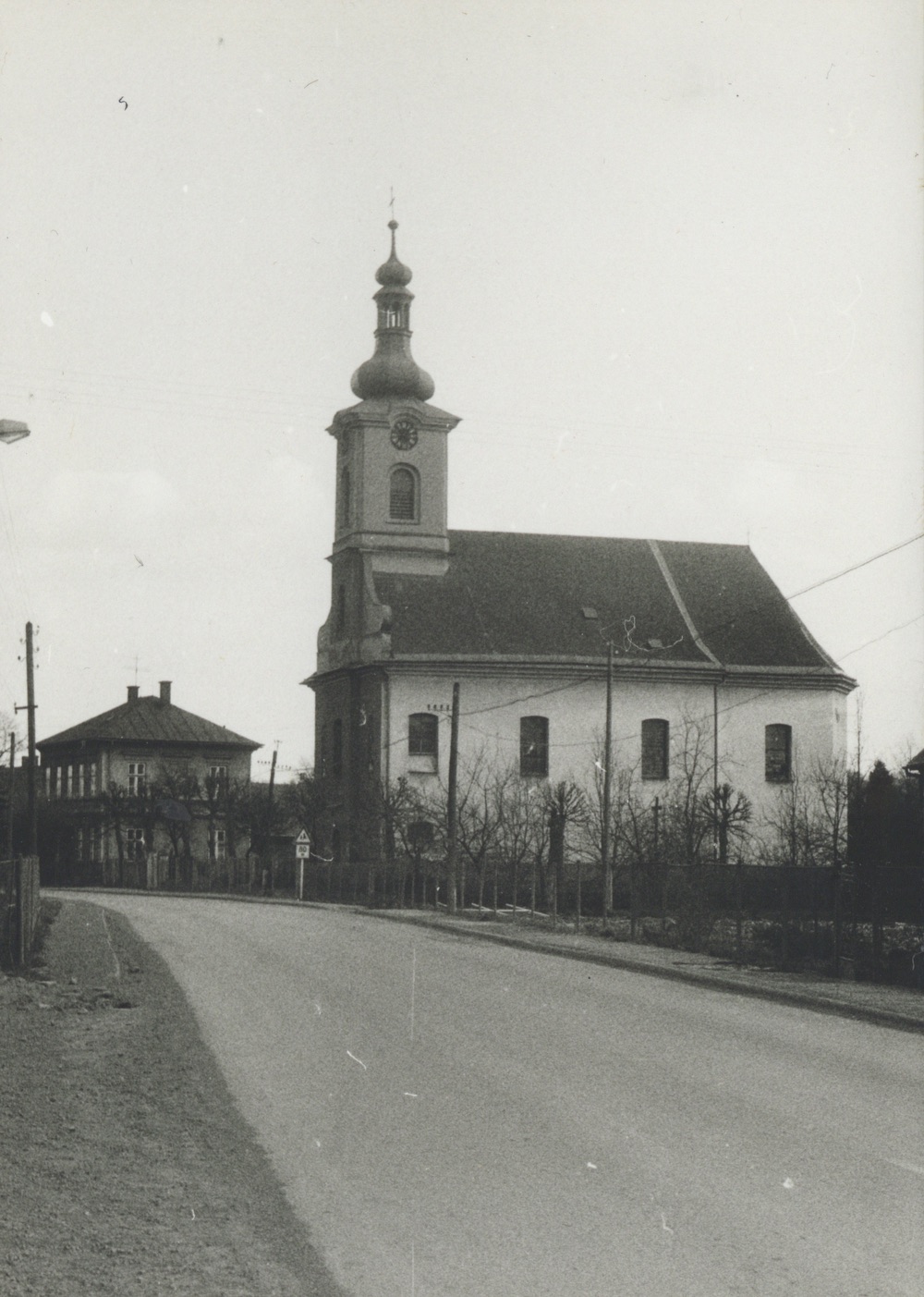 Kostel sv. Barbory a za ním budova Farního úřadu v Loukách čp. 29 (se svolením autora fotografie p. Bronislava Filipczyka, ze soukromé sbírky)