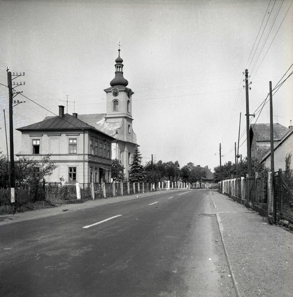 Vlevo Farní úřad čp. 29 a kostel sv. Barbory v Loukách na snímku z roku 1965 (S laskavým svolením p. Davida Pindura, ze soukromého archivu)