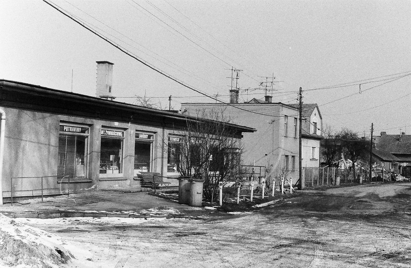 Vlevo prodejna potravin (samoobsluha), za ní domy čp. 352 (poslední obyvatelé: Malář R.), čp. 38 a čp. 100 (s laskavým svolením autora fotografie p. Bronislava Filipczyka, ze soukromé sbírky)