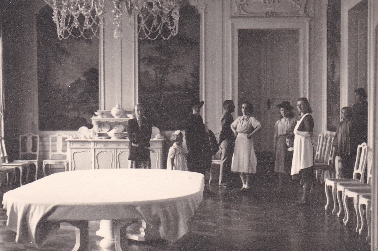 Malá Marie Cymorková (rozená Sikorová) s rodinou při prohlídce zámecké jídelny. Rok 1942 (Zdroj: E. Schweserová, P. Bindač: SOLCA Tajemství zámeckého parku = KLIK NA FOTOGRAFII. Foto G. Sikora, z rodinné sbírky Marie Cymorek)