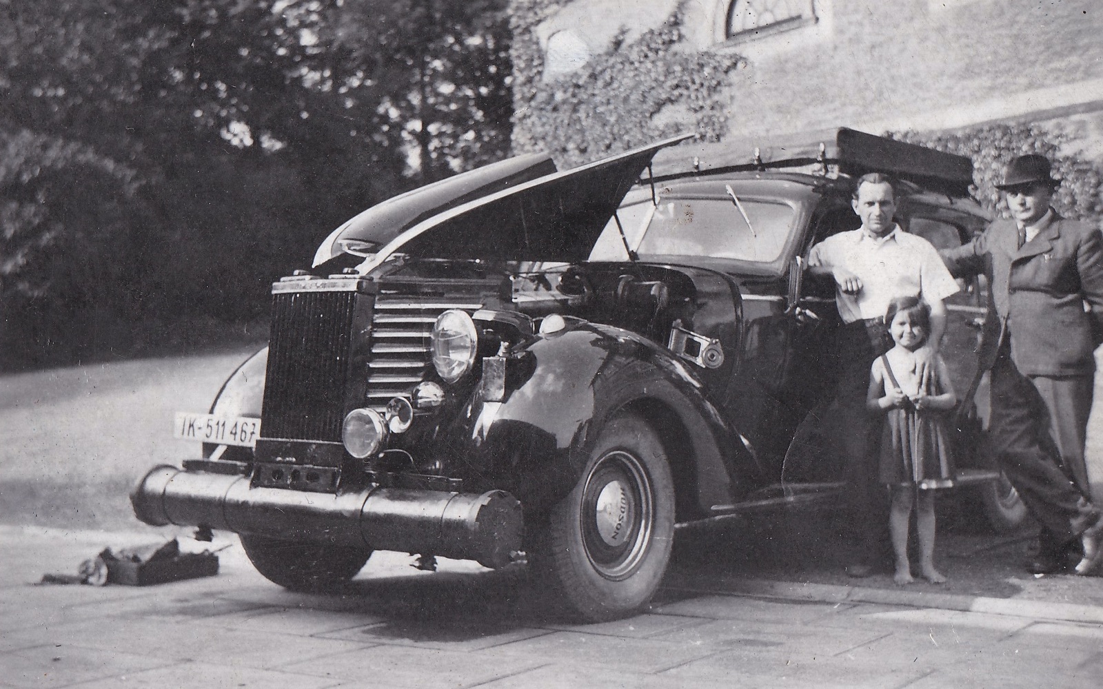 Řidič Alois Owczarzy s dcerou Helenou před budovou kočárovny u jednoho z vozů rodiny Larisch-Mönnich. Na snímku je americký automobil značky HUDSON 112 z roku 1938, upravený v období 2. sv. války pro pohon dřevoplynem. Rok 1942 (Zdroj: E. Schweserová, P. Bindač: SOLCA Tajemství zámeckého parku = KLIK NA FOTOGRAFII. Foto z rodinné sbírky Heleny Lukoszové)