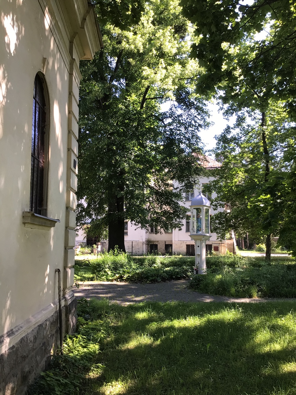 Panna Maria s Jezulátkem v prosklené schráně zdobeného, dřevěného sloupu a vlevo kaple sv. Anny (Darkov)