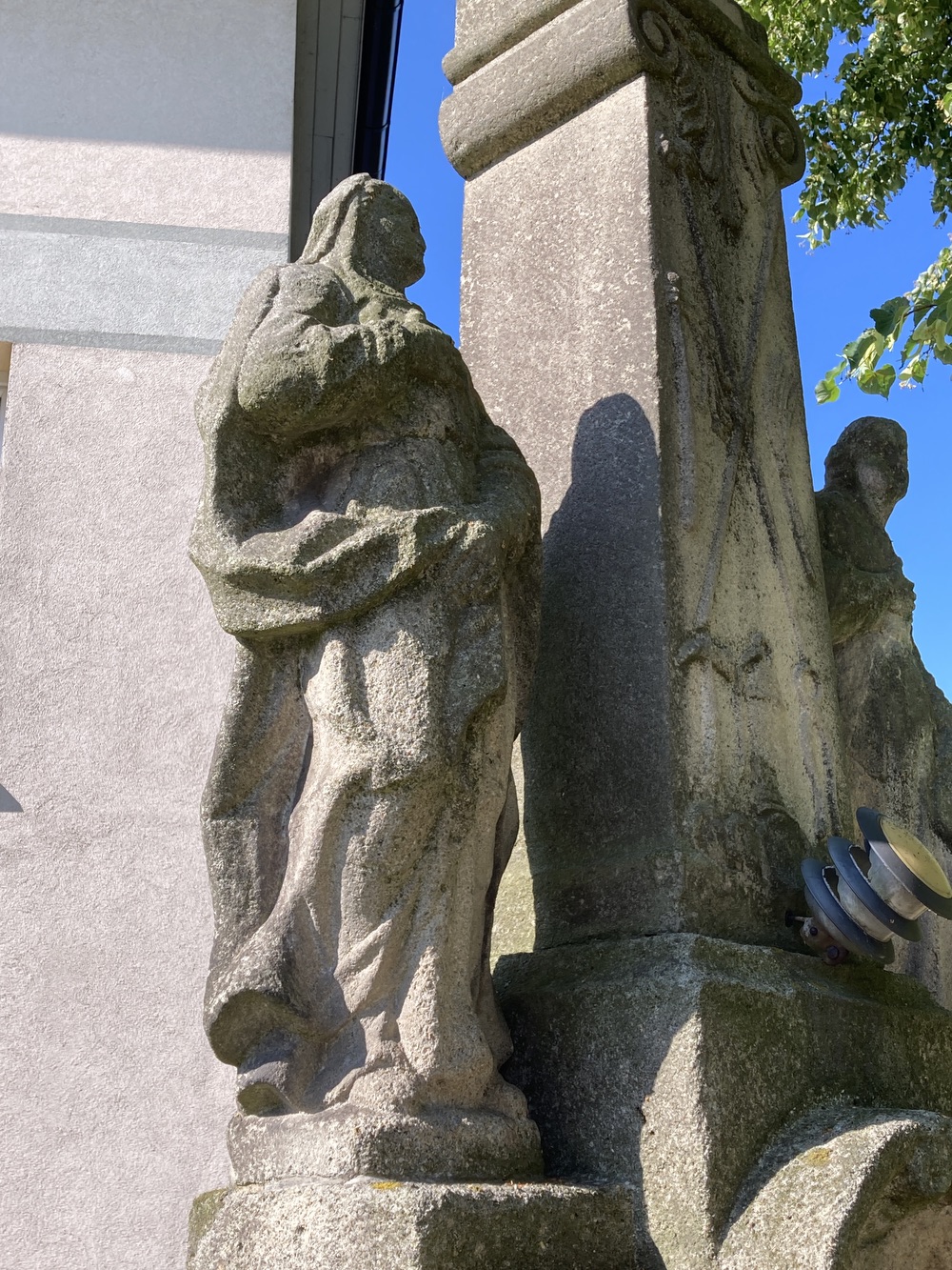 Sousoší Malé Kalvárie s reliéfem sv. Veroniky a postavami Panny Marie (vlevo) a sv. Jana (vpravo) po stranách kříže, z roku 1858 (Petrovice u Karviné, u čp. 153). KULTURNÍ PAMÁTKA