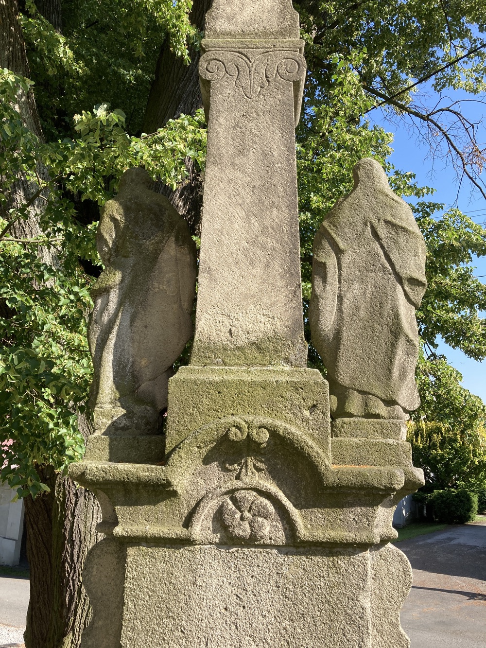 Sousoší Malé Kalvárie s reliéfem sv. Veroniky a postavami Panny Marie (vlevo) a sv. Jana (vpravo) po stranách kříže, z roku 1858 (Petrovice u Karviné, u čp. 153). KULTURNÍ PAMÁTKA