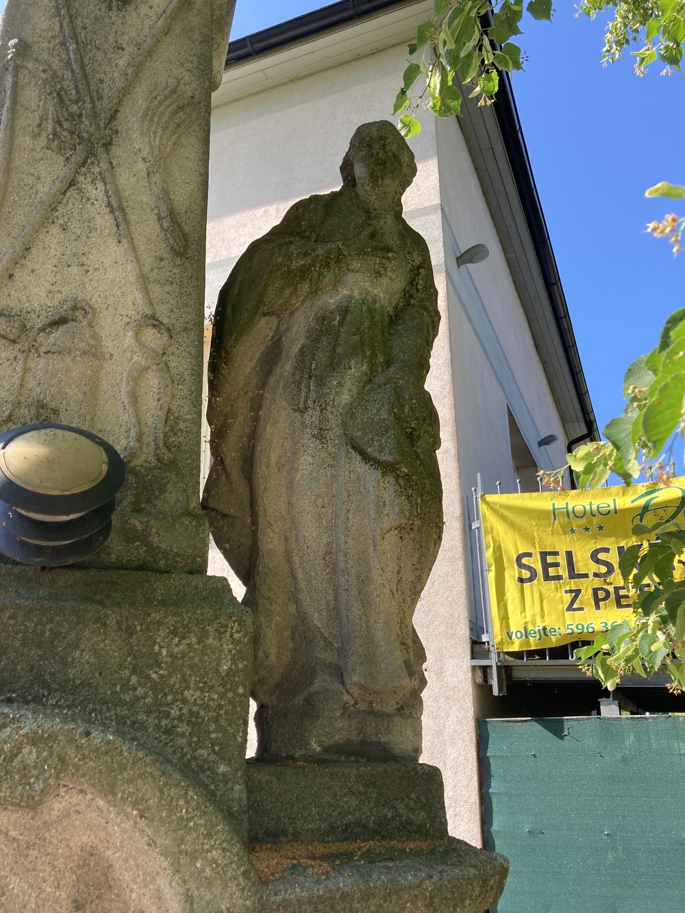Sousoší Malé Kalvárie s reliéfem sv. Veroniky a postavami Panny Marie (vlevo) a sv. Jana (vpravo) po stranách kříže, z roku 1858 (Petrovice u Karviné, u čp. 153). KULTURNÍ PAMÁTKA