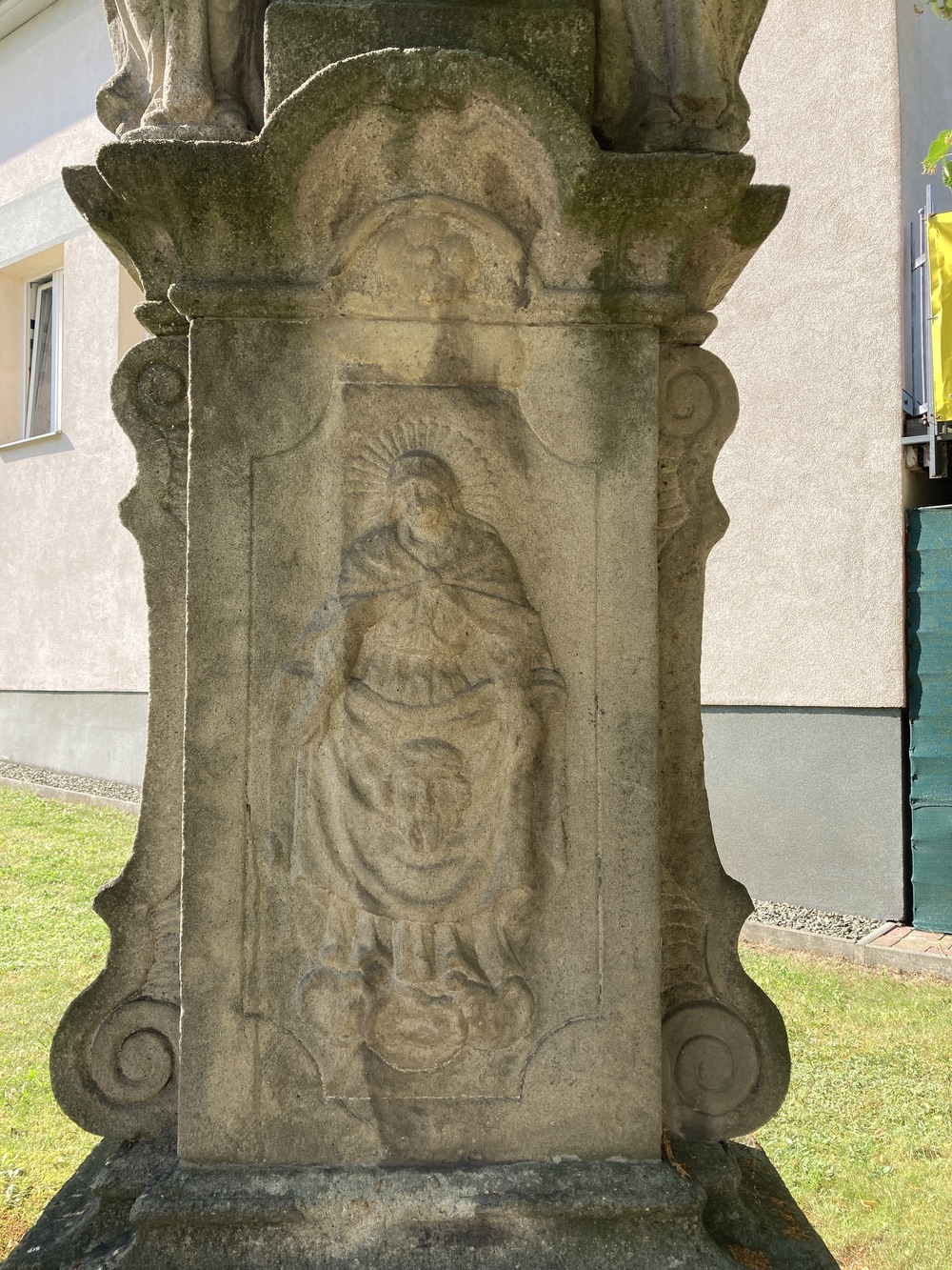 Sousoší Malé Kalvárie s reliéfem sv. Veroniky a postavami Panny Marie (vlevo) a sv. Jana (vpravo) po stranách kříže, z roku 1858 (Petrovice u Karviné, u čp. 153). KULTURNÍ PAMÁTKA