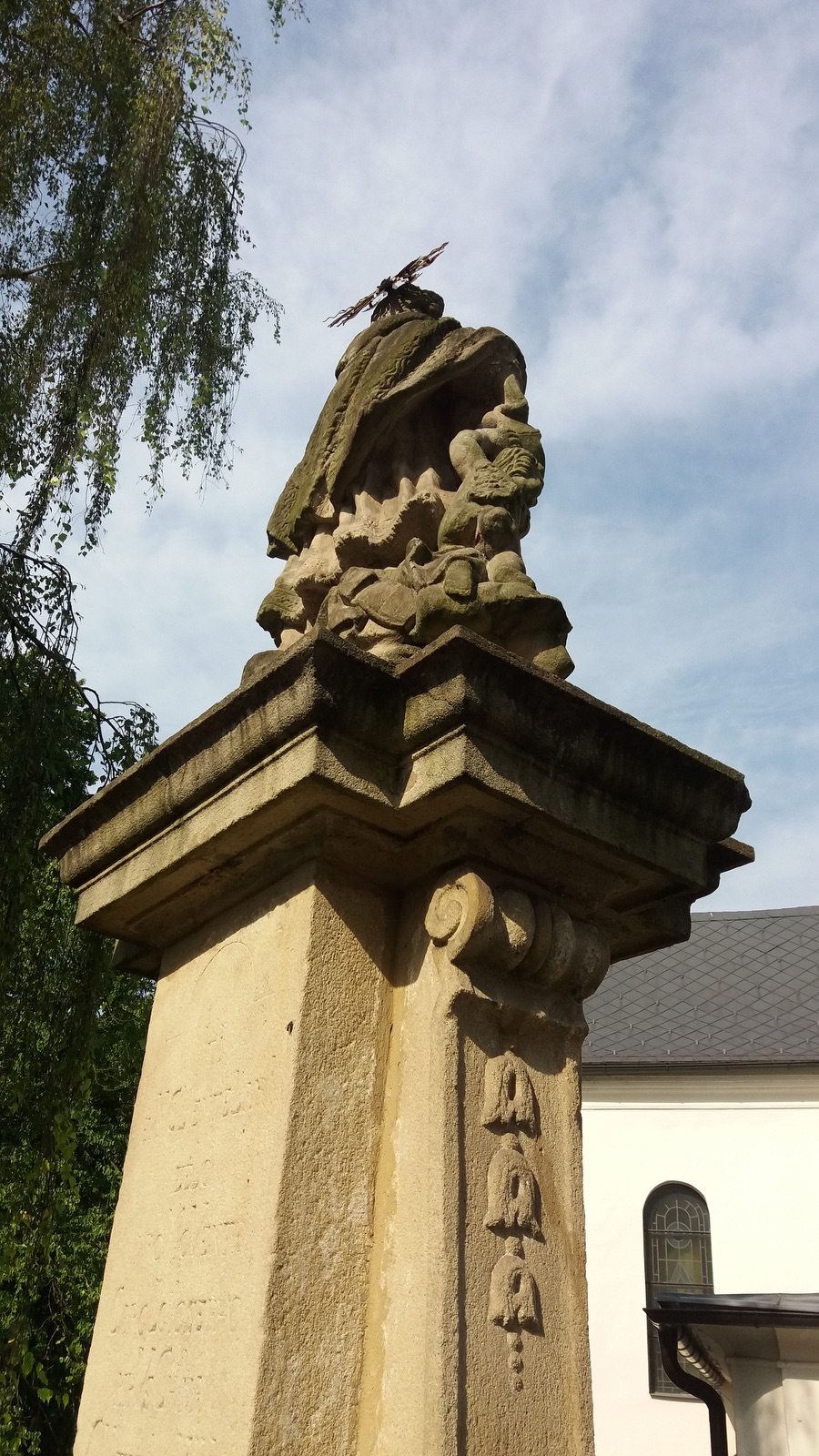Barokní socha svatého Jana Nepomuckého z roku 1747 za presbytářem kostela Povýšení sv. Kříže ve Fryštátě. Původně stála socha na náměstí, přibližně v místech před dnešním pomníkem T. G. Masaryka.