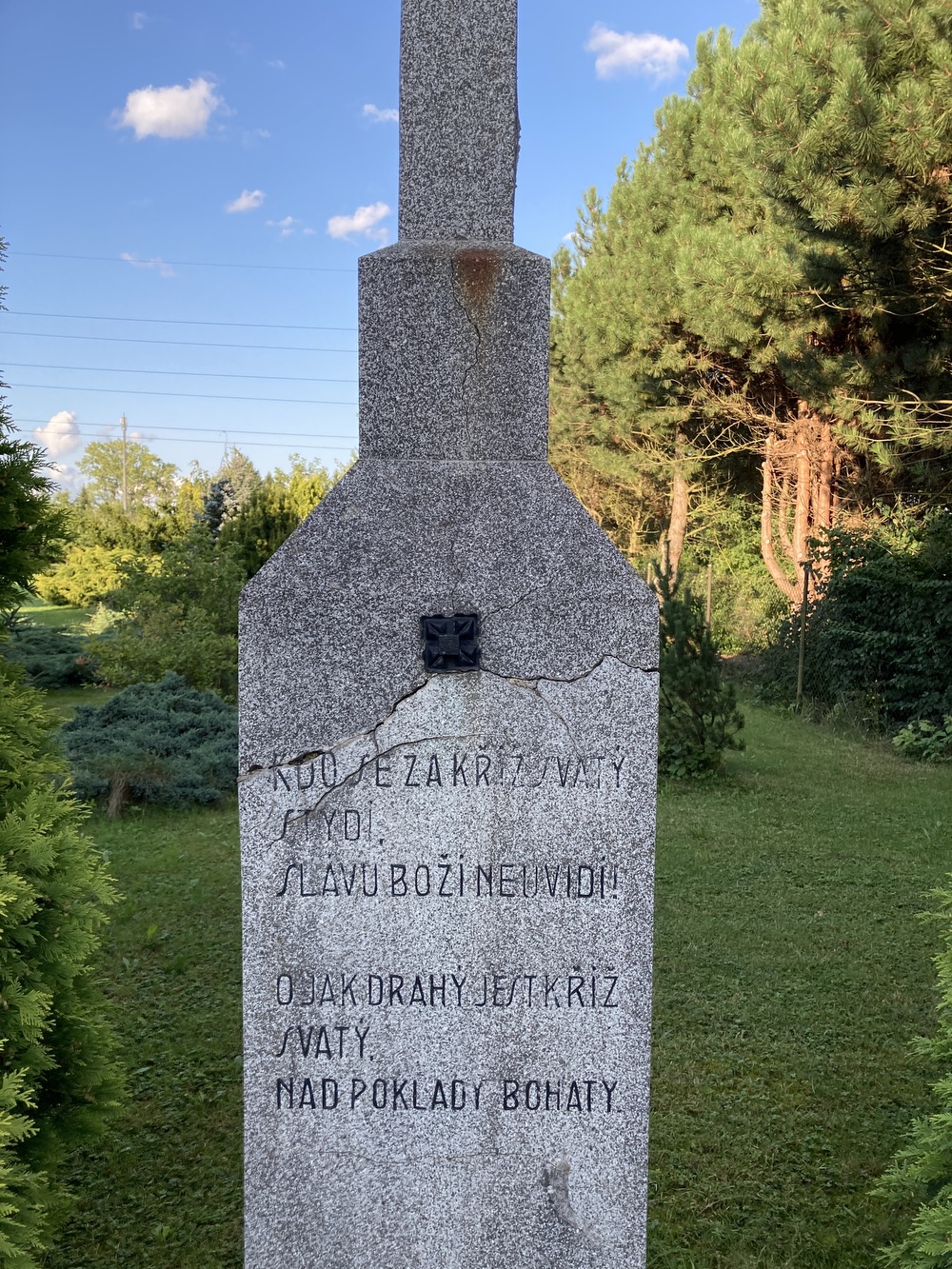 Kamenný kříž s Kristem v Dětmarovicích, u čp. 466. Nápis: Kdo se za kříž svatý stydí, slávu Boží neuvidí! Ó jak drahý jest kříž svatý, nad poklady bohatý. C.F.J.