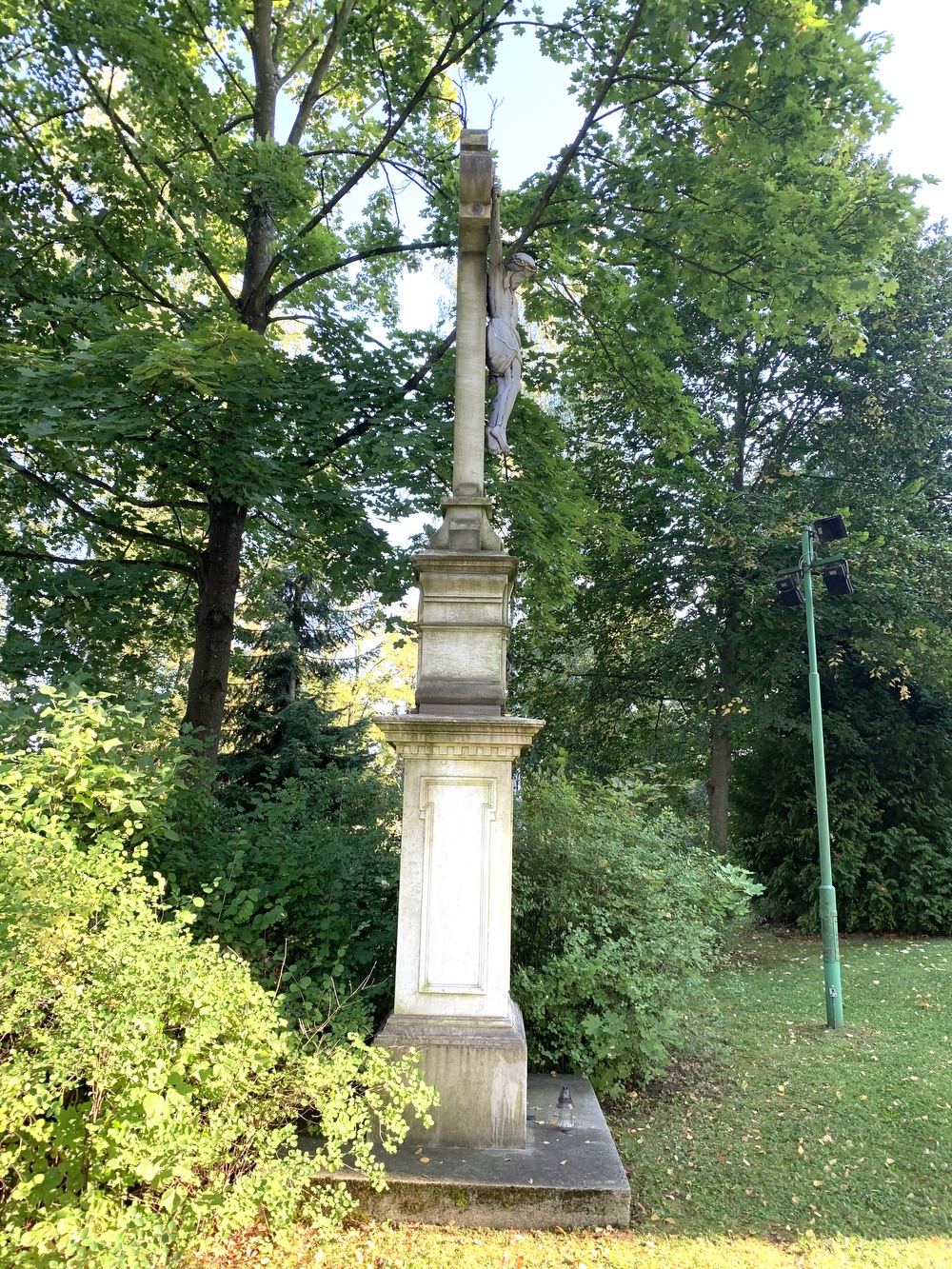 Kamenný kříž z roku 1894 u kostela sv. Petra a Pavla v Albrechticích. Kříž původně stával u kostela sv. Jindřicha ve staré Karvinné. (Fotografováno: 26.9.2023. Autor: Szarowská Olga)