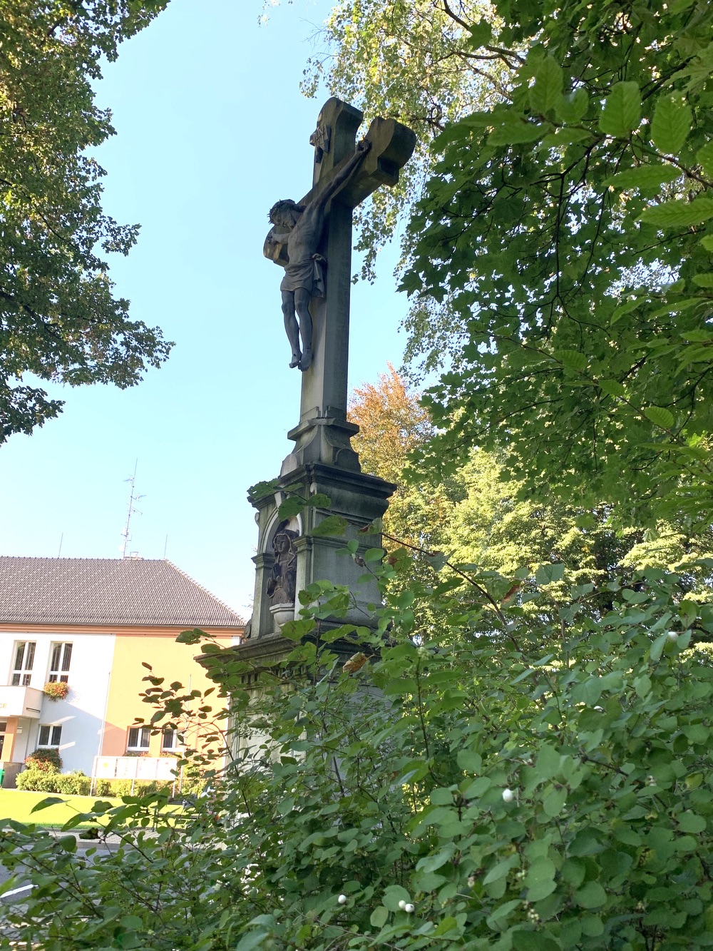 Kamenný kříž z roku 1894 u kostela sv. Petra a Pavla v Albrechticích. Kříž původně stával u kostela sv. Jindřicha ve staré Karvinné. (Fotografováno: 26.9.2023. Autor: Szarowská Olga)