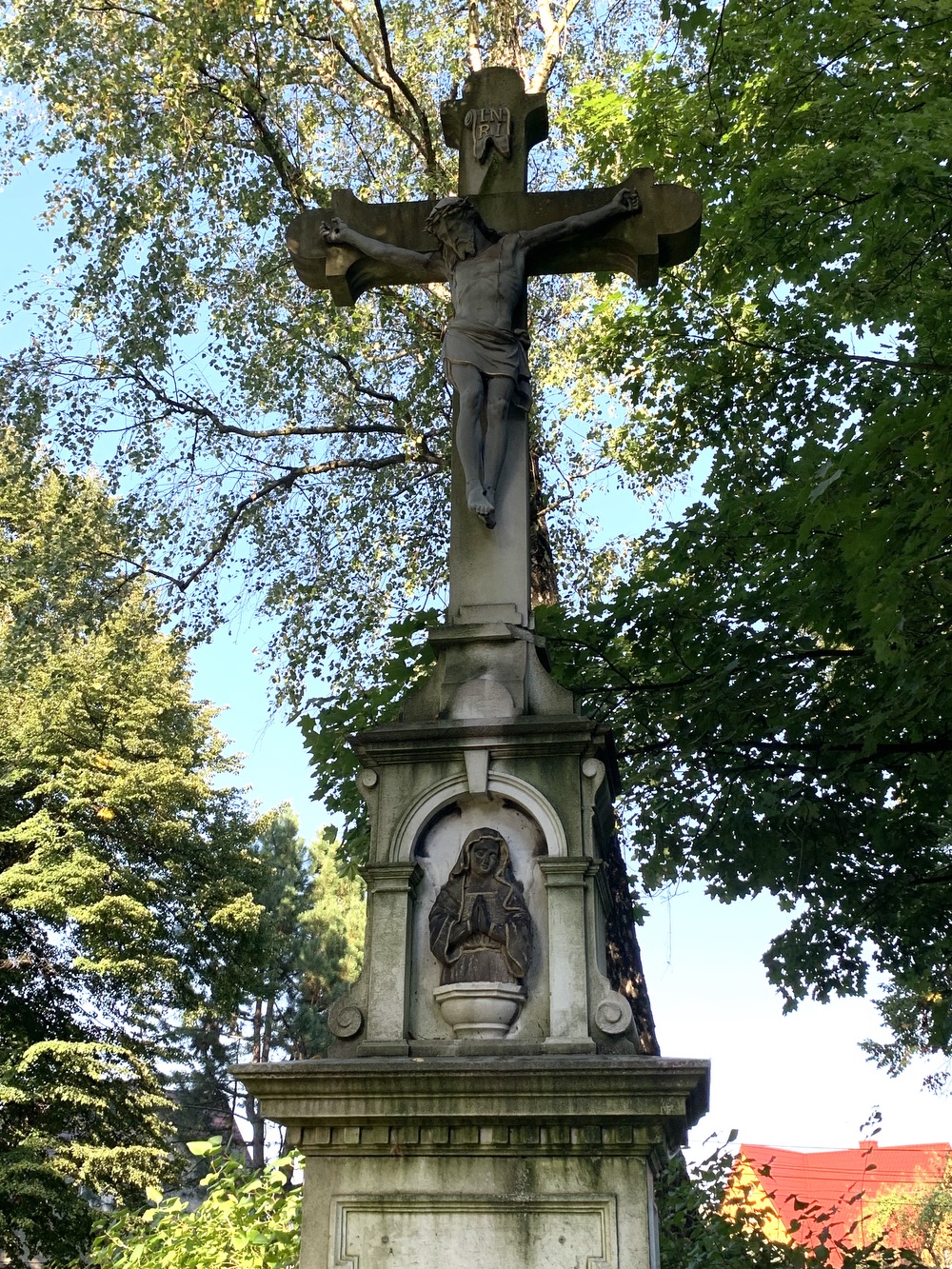 Kamenný kříž z roku 1894 u kostela sv. Petra a Pavla v Albrechticích. Kříž původně stával u kostela sv. Jindřicha ve staré Karvinné. (Fotografováno: 26.9.2023. Autor: Szarowská Olga)