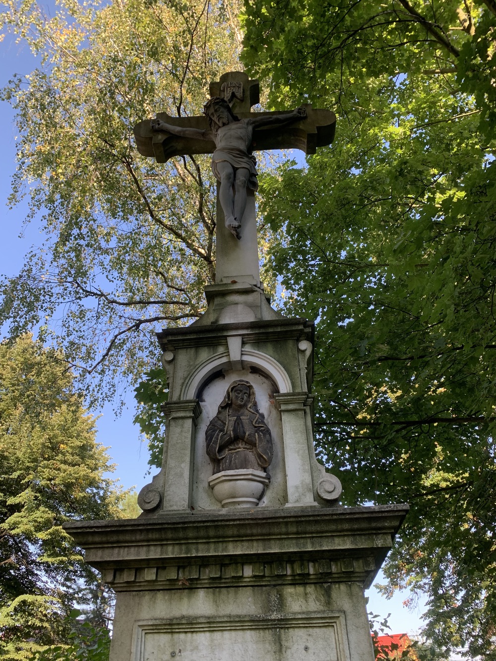 Kamenný kříž z roku 1894 u kostela sv. Petra a Pavla v Albrechticích. Kříž původně stával u kostela sv. Jindřicha ve staré Karvinné. (Fotografováno: 26.9.2023. Autor: Szarowská Olga)