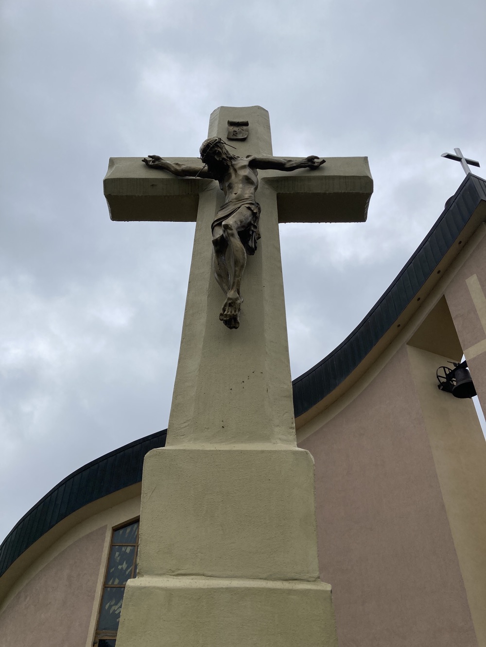 Kamenný kříž s Kristem před novým kostelem sv. Barbory v Loukách