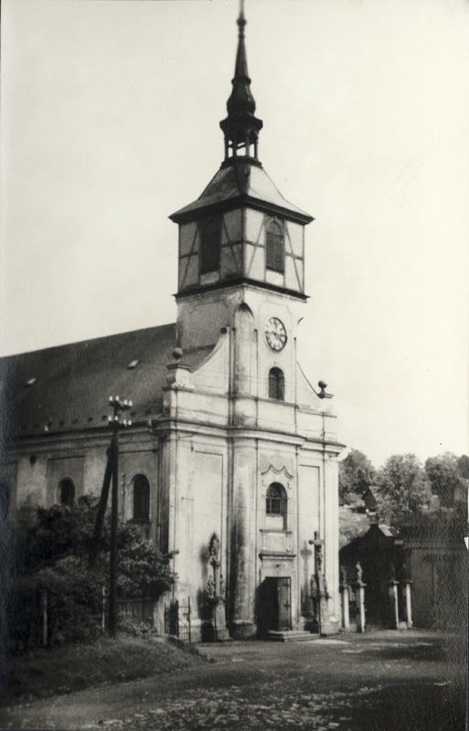 Kostel sv. Petra z Alkantary. Před vchodem do kostela vlevo sloup se sochou Panny Marie a sochami sv. Anny a sv. Jáchyma, vpravo pak krucifix se sochami sv. Jana a Panny Marie.