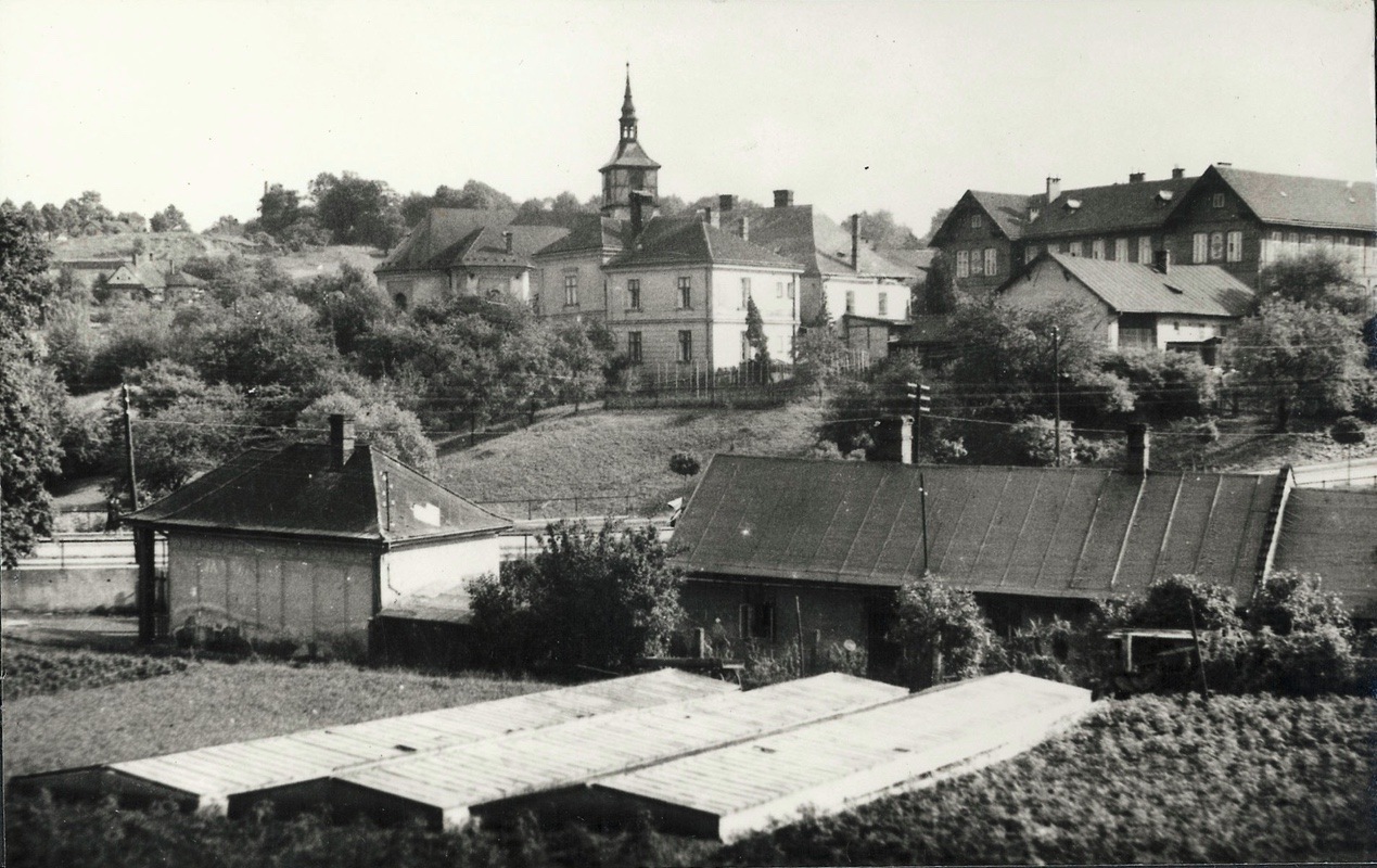 V popředí zahradnictví Dvořák, za silnicí budovy farního úřadu (čp. 12), tzv. Červená škola a kostel sv. Petra z Alkantary (rok 1943)