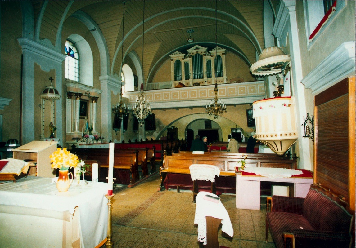 Interiér kostela sv. Petra z Alkantary, pohled směrem od oltáře k hlavnímu vchodu. (Barevná fotografie neznámého autora z roku 1993, Státní okresní archiv Karviná, 5760/17)